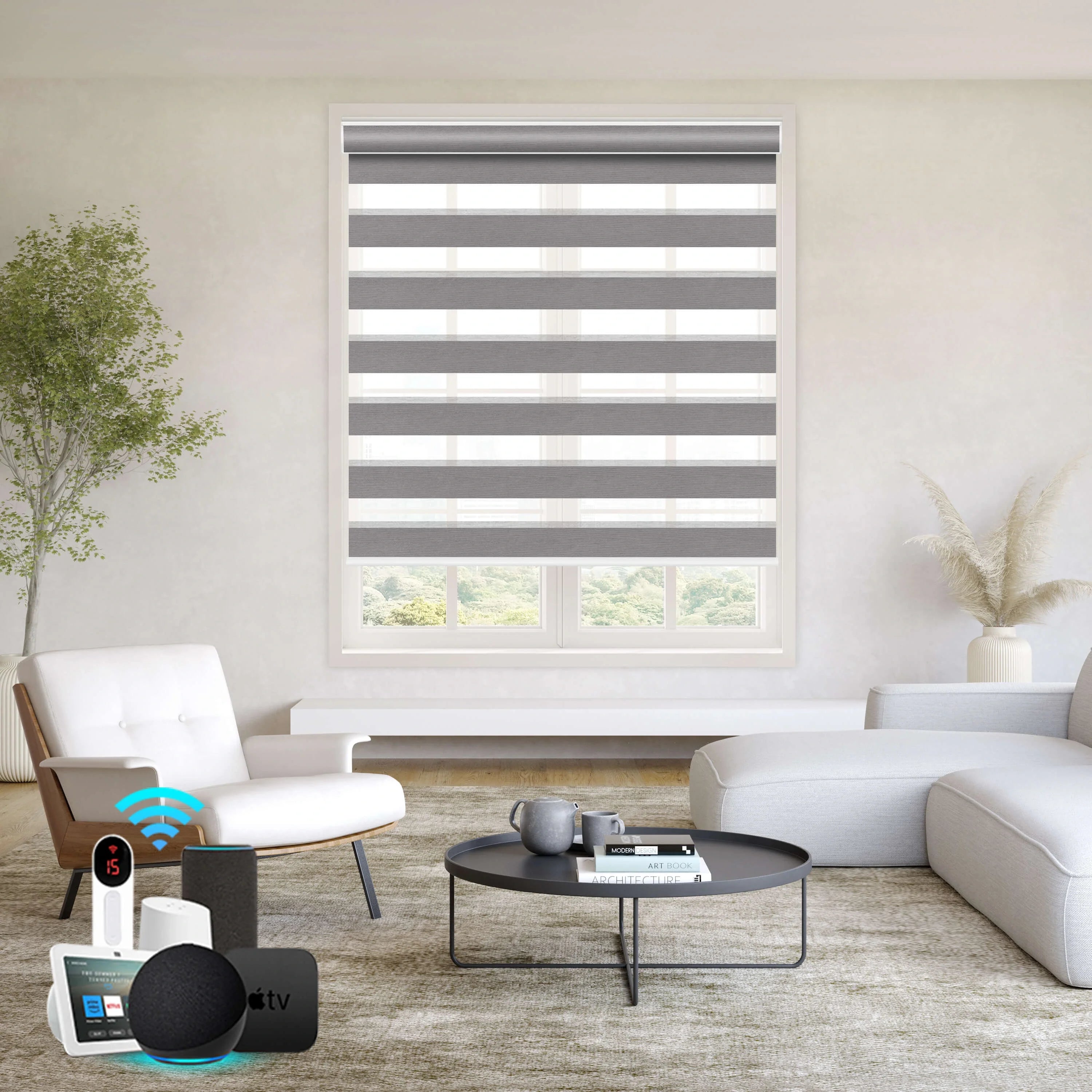 Motorized zebra roller shades in modern living room with white sectional sofa, round coffee table, and smart home voice control devices, overlooking green landscape.